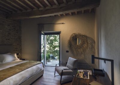 Ristrutturazione della villa La Palazzaccia da parte di Pelizzari, progetto di design d'interni con dettagli in legno naturale, ampi spazi luminosi e finiture di pregio.