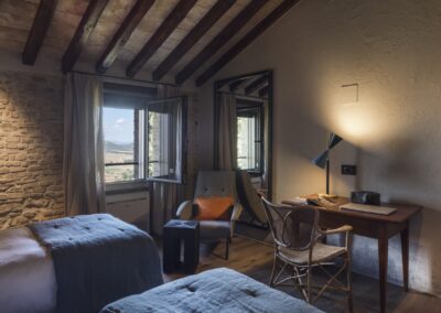 Ristrutturazione della villa La Palazzaccia da parte di Pelizzari, progetto di design d'interni con dettagli in legno naturale, ampi spazi luminosi e finiture di pregio.